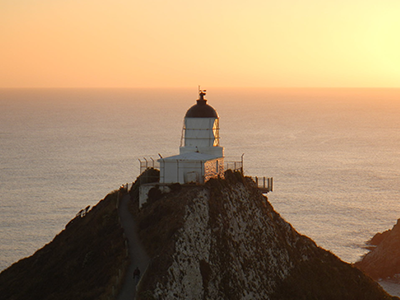 Lighthouse at sunrise on cliff